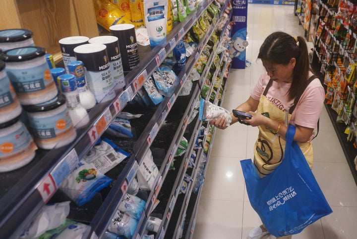 A substitute shopper helps an online customer buy salt at a supermarket in Hangzhou, Zhejiang province, China, on Aug. 24. As Japan started to discharge contaminated water from the Fukushima Daiichi nuclear power plant into the sea, some Hangzhou residents bought a large amount of salt in a questionable bid to prevent radiation sickness.