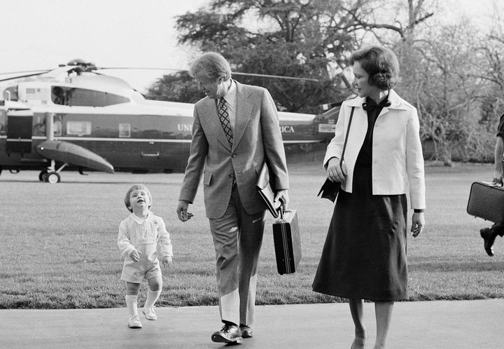 FILE – In this photo from April 11, 1977, then-President Jimmy Carter and his wife Rosalynn are joined by their grandson Jason, two-years-old, as they return to the White House after a holiday weekend in Calhoun, Georgia. (AP Photo/ Peter Bregg)