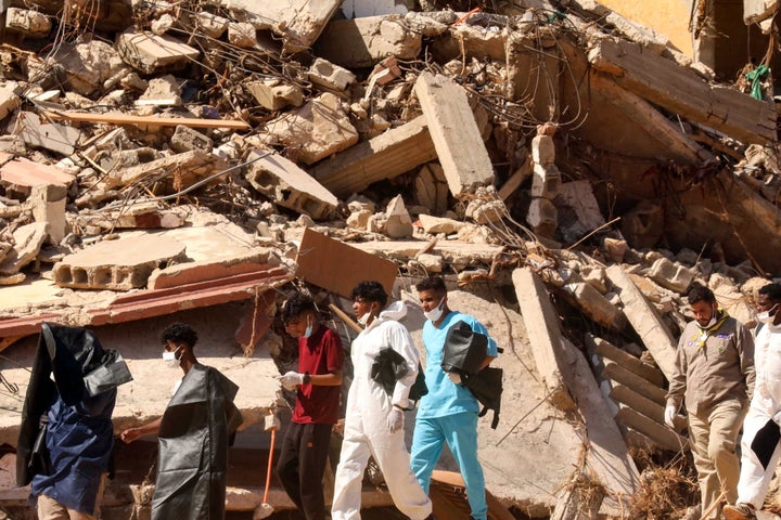 Rescuers carry body bags as they walk in front of buildings that collapsed during floods after the Mediterranean storm "Daniel" hit Libya's eastern city of Derna, on September 14, 2023. Aid groups have warned of growing risk posed by the spread of disease that could compound the humanitarian crisis in Libya, as hopes of finding more survivors fade days after the deadly flooding. (Photo by Abdullah DOMA / AFP) (Photo by ABDULLAH DOMA/AFP via Getty Images)