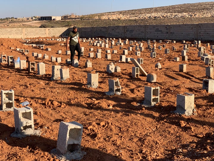 A man walks by the graves of the flash flood victims in Derna, Libya, Friday, Sept. 15, 2023. The death toll in Libya's coastal city of Derna has soared to over ten thousand as search efforts continue following a massive flood fed by the breaching of two dams in heavy rains, the Libyan Red Crescent said Thursday. (AP Photo/Yousef Murad)