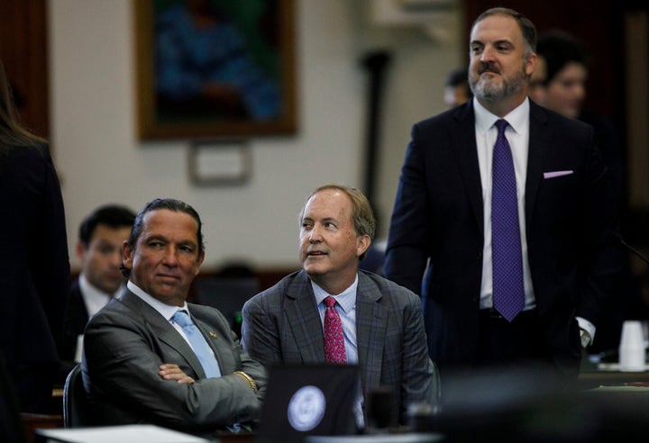 Texas Attorney General Ken Paxton, center, sits between defense attorneys Tony Buzbee, left, and Mitch Little, right, before his impeachment trial resumes in the Senate Chamber at the Texas Capitol on Friday, Sept. 15, 2023, in Austin, Texas. (Sam Owens/The San Antonio Express-News via AP, Pool)