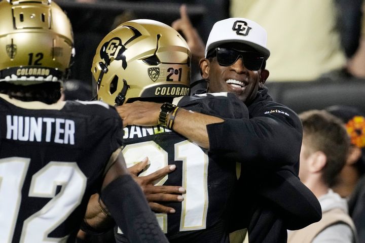 Colorado head coach Deion Sanders, right, hugs his son, safety Shilo Sanders, after he returned an interception for a touchdown in the first half of a game against Colorado State on Saturday in Boulder, Colorado. (AP Photo/David Zalubowski)