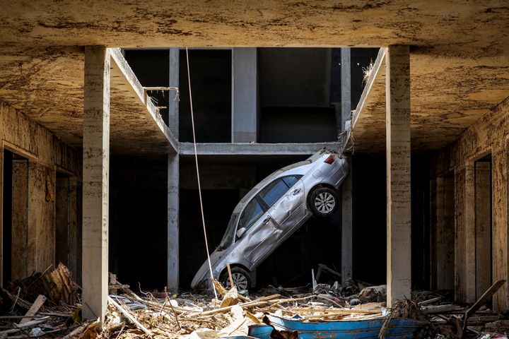 A tilted car lies on rubble in the eastern Libyan city of Derna on September 18, following deadly flash floods.