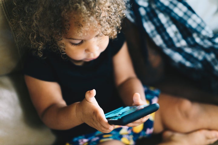 Little girl uses a cellphone