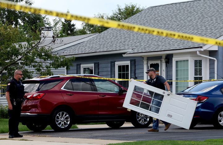 A Romeoville Police officer carries out a door from inside of the home where four people were shot to death, on Monday, Sept. 18, 2023, in Romeoville Ill.