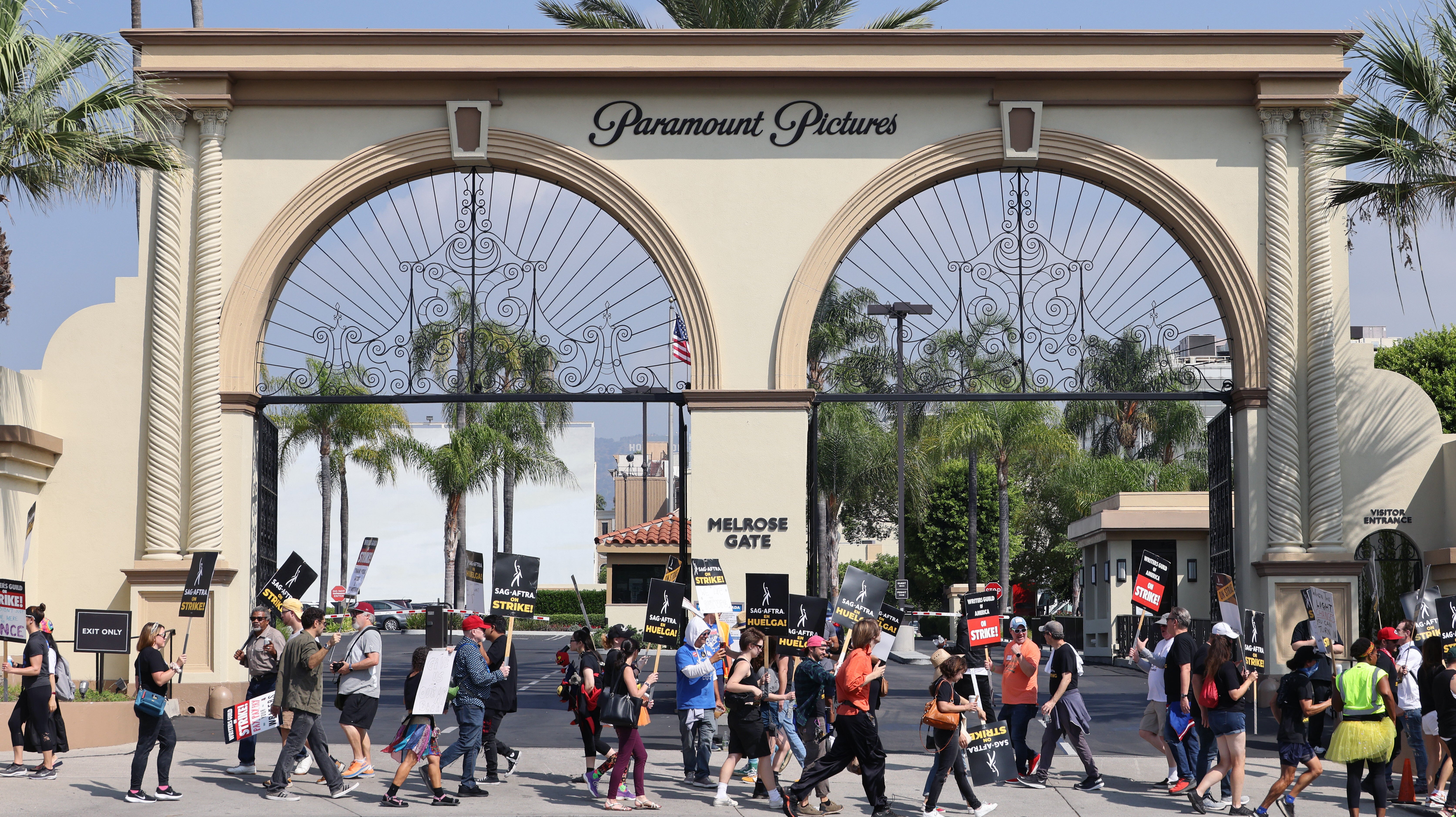 Picketing writer with "on strike" sign.