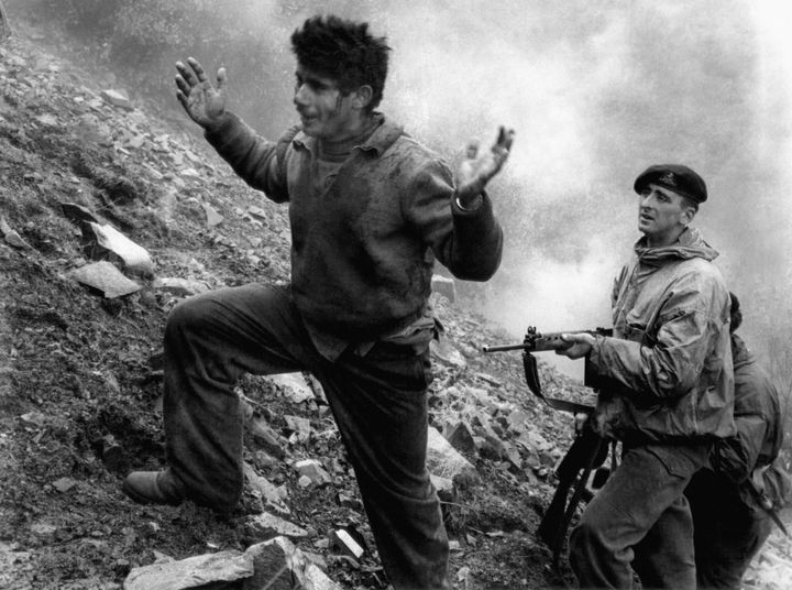 With hands raised, Agustinds Efstathios, 22, climbs up the Mountainside from his Eoka hideout on March 3, 1957 under the gun of a British soldier of the duke of Wellington’s regiment. He is one of three others who surrendered when their cave lair was surrounded by British troops. A fifth man, Gregoris Pieri Afxentios, second-in-command to Eoka chief colonel Grivas and bearing a price of $5,000 on his head, refused to surrender and fought in out with the soldiers until blasted to death in the cave that was hidden in a deep valley of the trodos mountains of Cyprus, a mile from the Isolated monastery of Macheras. (AP Photo)