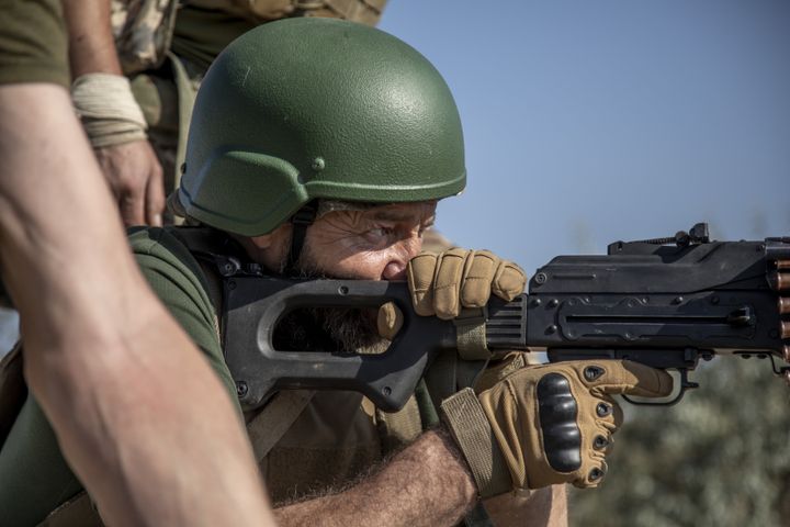 A Ukrainian soldier shoots a machine gun during training in Ukraine's Donbas region on Wednesday. 