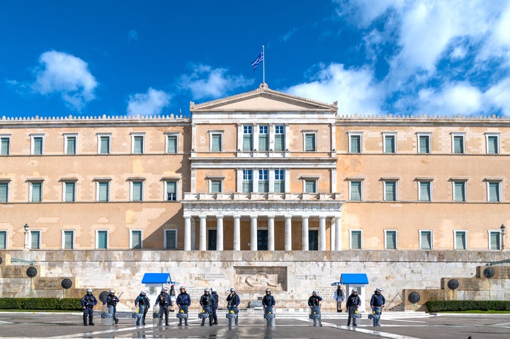 This is a photo of riot police is full gear protecting the Greek parliament in Athens, Greece