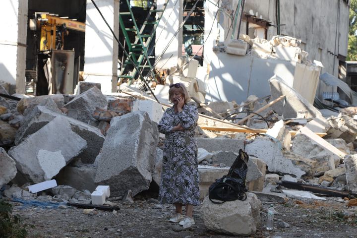 A woman talks on a mobile phone next an industrial building damaged after a Russian attack in the Odesa region, in southern Ukraine on September 25, 2023.