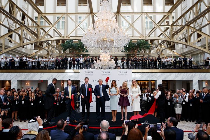 In this Wednesday, Oct. 26, 2016, file photo, Republican presidential candidate Donald Trump, accompanied by, from left, Donald Trump Jr., Eric Trump, Trump, Melania Trump, Tiffany Trump and Ivanka Trump, holds up a ribbon during the grand opening ceremony of the Trump International Hotel- Old Post Office, in Washington. Several experts in government contract law say that President-elect Trump will have to give up his stake in his prized Washington, D.C., hotel if he wants to be president.