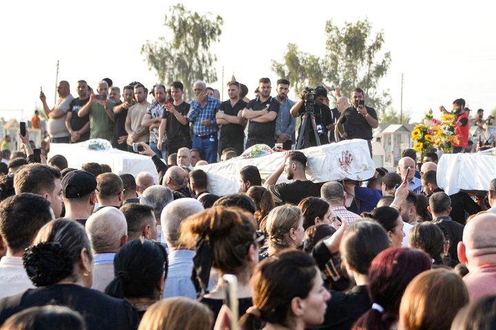 Mourners attend the funeral of victims who were killed in the fire.