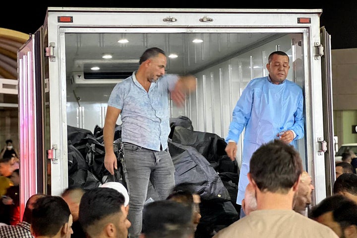 People gather around a truck carrying body bags outside of a hospital in Al-Hamdaniyah, Iraq, on Wednesday.