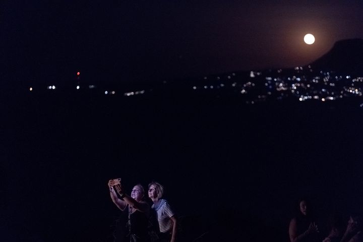 Δύο γυναίκες βγάζουν selfie με το «Μπλε Φεγγάρι» καθώς αυτό ανατέλλει πάνω από ένα βουνό στο Φρούριο Κούλες στην περιοχή Απτέρα στα Χανιά της Κρήτης (31/8/2023).