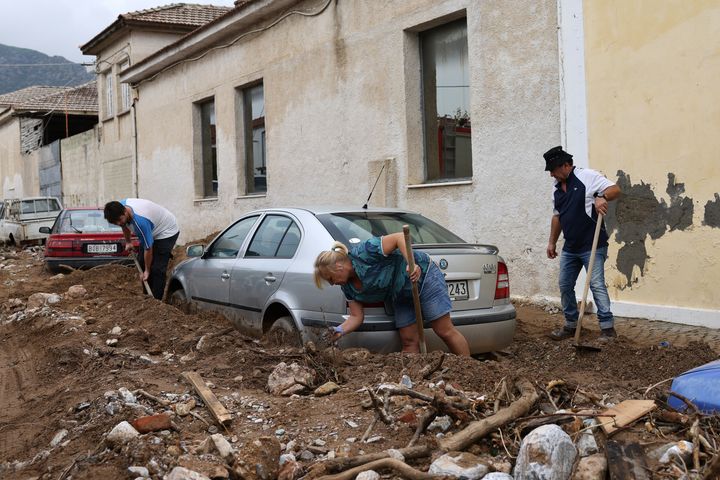 ΒΟΛΟΣ, ΕΛΛΑΔΑ - 28 ΣΕΠΤΕΜΒΡΙΟΥ: Άνθρωποι αφαιρούν λάσπη από ένα αυτοκίνητο μετά την καταιγίδα ΕLIAS στον Βόλο. Η καταιγίδα έριξε βροχή αρκετών μηνών σε λιγότερο από μια μέρα καθώς σάρωσε ολόκληρη την Ελλάδα, μόλις εβδομάδες μετά την καταιγίδα Ντάνιελ που σκότωσε 17 ανθρώπους. Χωριά πλημμύρισαν, δρόμοι πλημμύρισαν και σχολεία αναγκάστηκαν να κλείσουν σε αρκετούς δήμους. (Photo by Costas Baltas/Anadolu Agency via Getty Images)