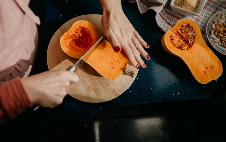 Warning: Don't cut your squash like this! The cut side should be facing down on the cutting board, so the squash doesn't roll while you attempt to slice it.