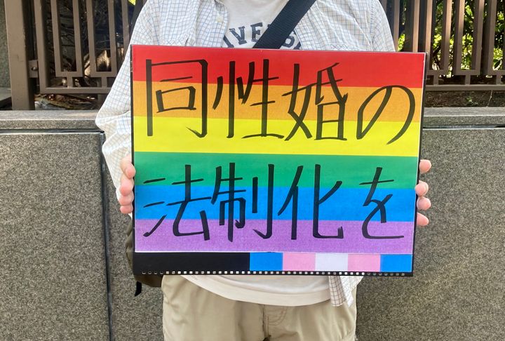 裁判所の前で「同性婚の法制化を」というメッセージを掲げる支援者