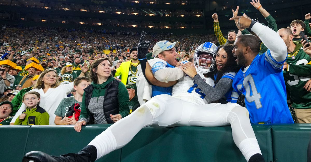 Packers fan dumps beer on Amon-Ra St. Brown after Lambeau Leap