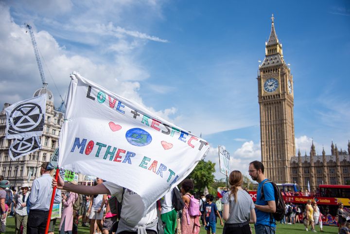 A protester holds a large banner at Parliament Square in London during the March To Demand An End To Fossil Fuels.