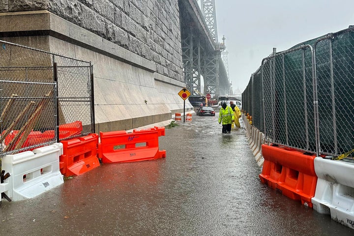 First responders wade through flood waters at the base of the Williamsburg Bridge, Friday, Sept. 29, 2023, in New York.