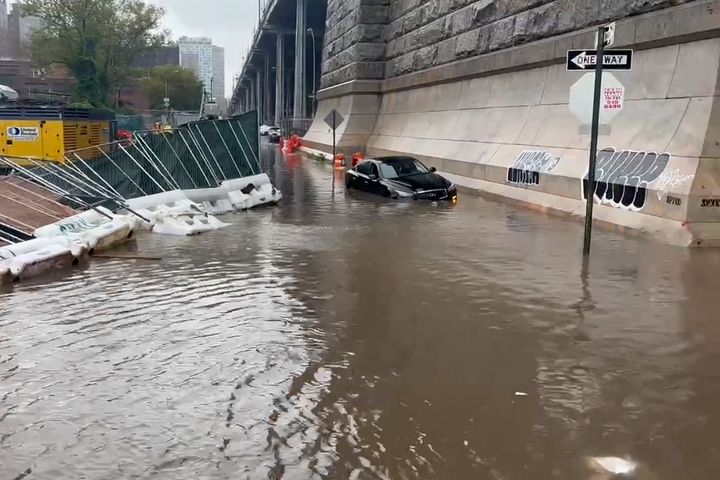 In this image taken from video, a car sits stranded in flood waters at the base of the Williamsburg Bridge, Friday, Sept. 29, 2023, in New York. A potent rush-hour rainstorm has swamped the New York metropolitan area. The deluge Friday shut down swaths of the subway system, flooded some streets and highways, and cut off access to at least one terminal at LaGuardia Airport. (AP Photo/Jake Offenhartz)