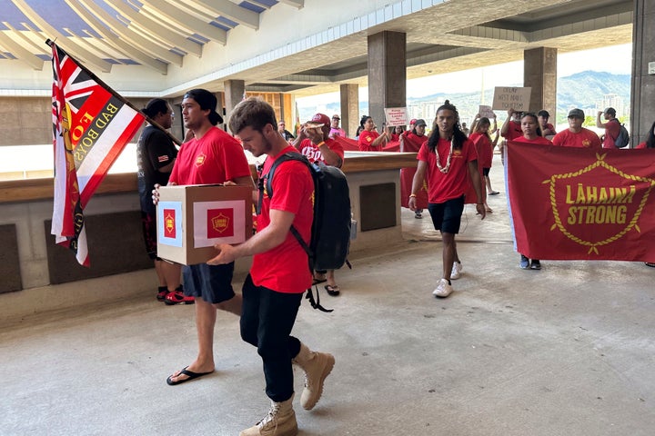 Lahaina residents and their supporters walk at the Hawaii State Capitol in Honolulu on Oct. 3, 2023, to deliver a petition asking Hawaii Gov. Josh Green to delay plans to reopen a portion of West Maui to tourism starting this weekend.