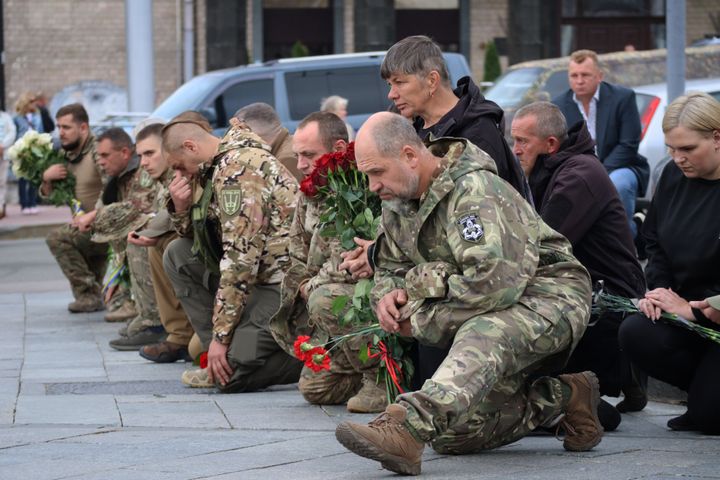 Prajurit Ukraina di Kyiv berlutut pada hari Rabu di depan peti mati Oleksandr Pastukh saat pemakaman sersan Angkatan Bersenjata Ukraina.