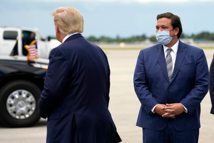 Then-President Donald Trump greets Florida Gov. Ron DeSantis as he arrives at West Palm Beach International Airport on Sept. 8, 2020.