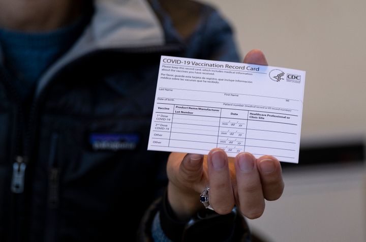 A nurse practitioner holds a COVID-19 vaccine card at a New York Health and Hospitals vaccine clinic in the Brooklyn borough of New York on Jan. 10, 2021. Now that COVID-19 vaccines are being distributed through the commercial markets instead of by the federal government in 2023, the Centers for Disease Control and Prevention won't be shipping out any more new cards. 