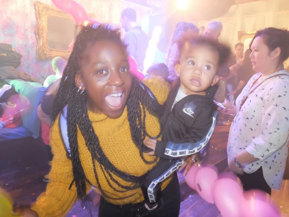 A mother attends a family friend rave with her toddler. 