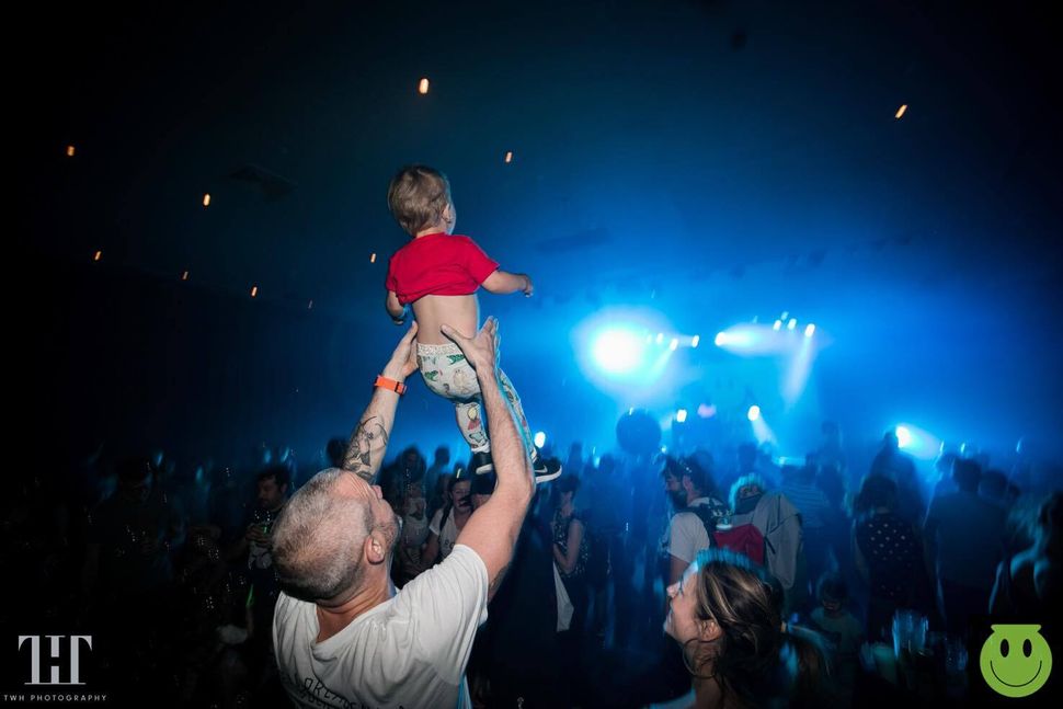 A father and his child enjoy the visuals at a Big Fish Little Fish rave.