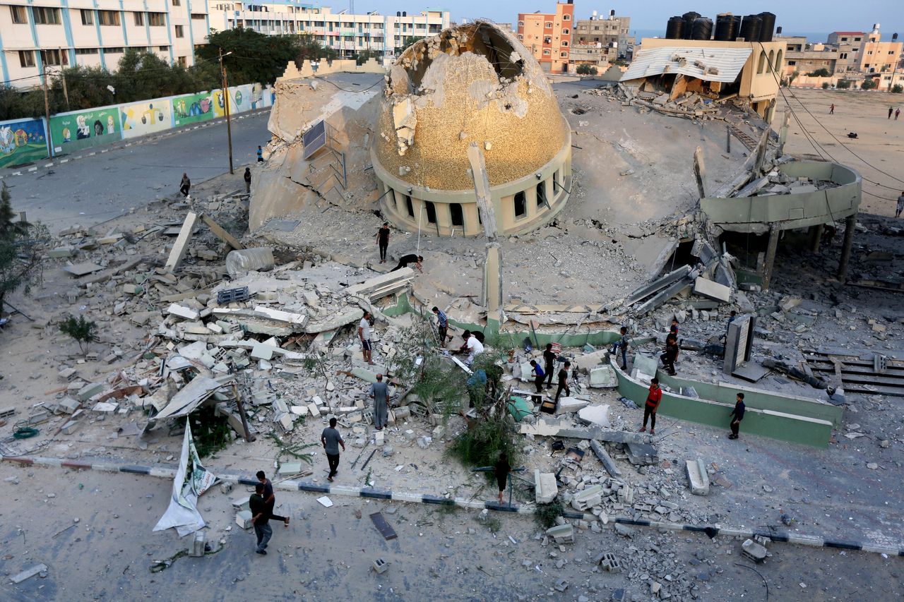 Aνθρωποι στέκονται έξω από ένα τέμενος που καταστράφηκε σε μια ισραηλινή αεροπορική επιδρομή στο Χαν Γιουνίς, στη Λωρίδα της Γάζας, Κυριακή, 8 Οκτωβρίου 2023.(AP Photo/Yousef Masoud, File)