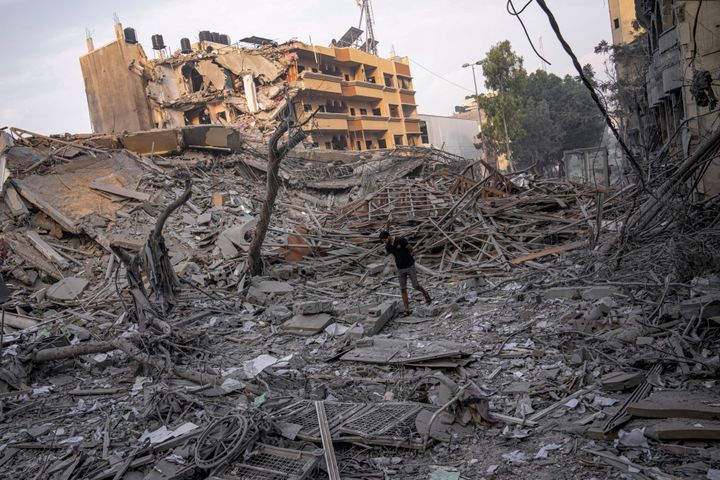 Palestinians inspect the rubble of a building after it was struck by an Israeli airstrike, in Gaza City, on Sunday. The militant Hamas rulers of the Gaza Strip carried out an unprecedented, multi-front attack on Israel at daybreak Saturday, firing thousands of rockets as dozens of Hamas fighters infiltrated the heavily fortified border in several locations by air, land and sea, killing hundreds and taking captives. Palestinian health officials reported scores of deaths from Israeli airstrikes in Gaza.