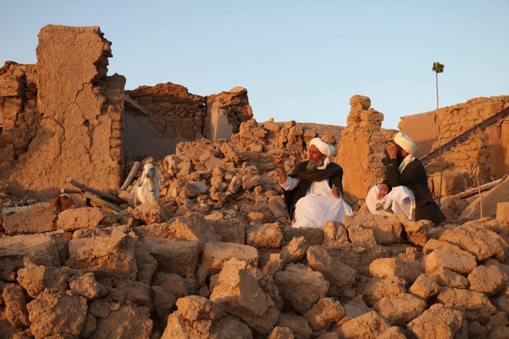 地震によりがれきとなった家屋に座り込む住民（アフガニスタン西部ヘラート州）＝10月7日
