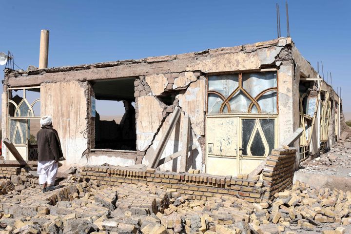 被災した家屋の近くに立つアフガニスタン人男性＝10月8日