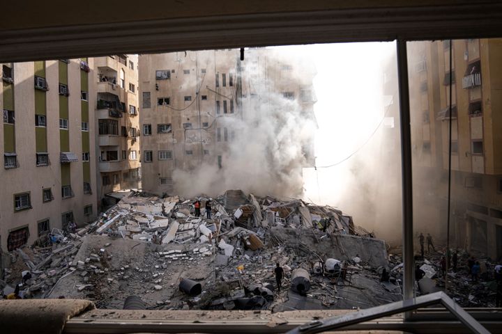 イスラエルの空爆によって破壊されたガザ地区の建物を調べるパレスチナの人たち（10月7日）