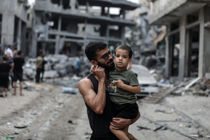 Palestinians inspect the destruction in a neighbourhood heavily damaged by Israeli airstrikes on Gaza City's Shati refugee camp early on October 9, 2023.