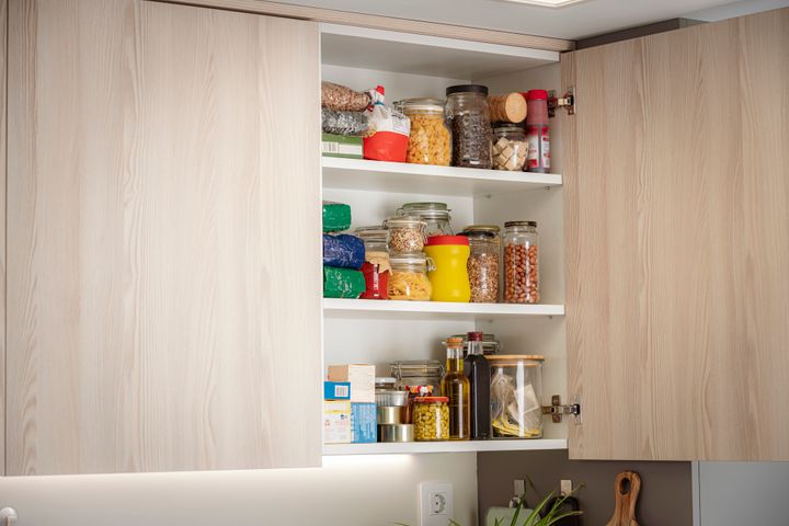 Open cabinet full of groceries in a modern kitchen