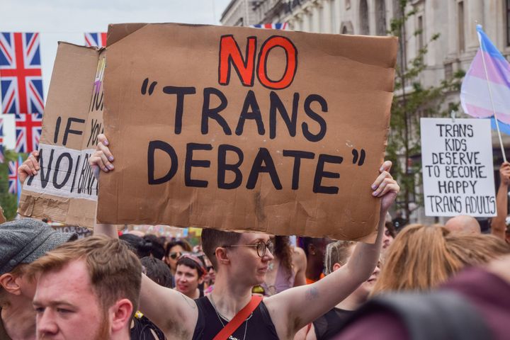 A protester holds a 'No trans debate' placard during the demonstration in Piccadilly Circus. Thousands of people marched through central London during Trans Pride 2023.