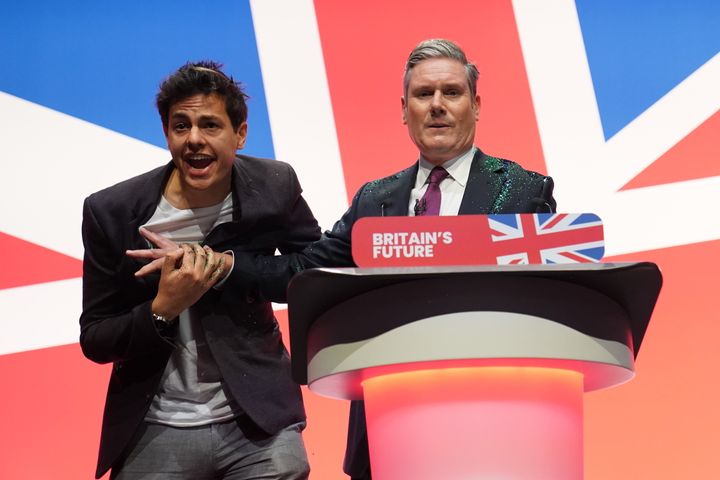 A protester throws glitter over and disrupts Labour leader Keir Starmer making his keynote speech during the Labour Party Conference in Liverpool. 