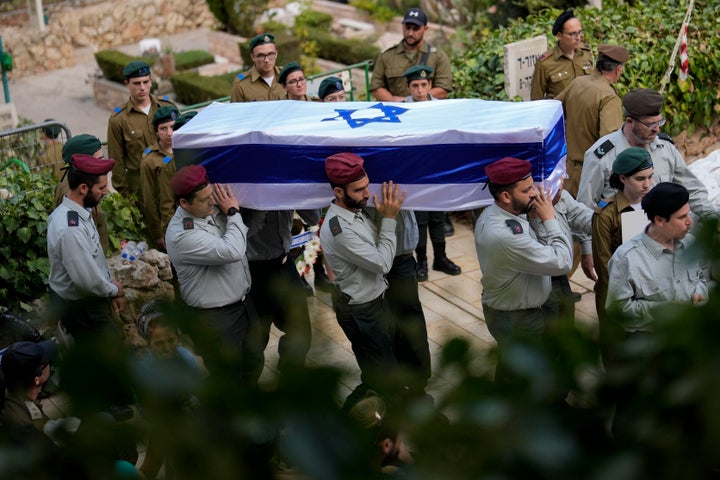 Israeli soldiers carry the flag-covered coffin of Maj. Tal Cohen during his funeral at the Givat Shaul cemetery in Jerusalem on Tuesday, Oct. 10, 2023. The latest Israel-Palestinian war reverberated around the world Tuesday, as foreign governments tried to determine how many of their citizens were dead, missing or in need of medical help or flights home. (AP Photo/Francisco Seco)