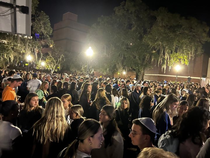 People are seen attending a vigil at the University of Florida on Monday night.