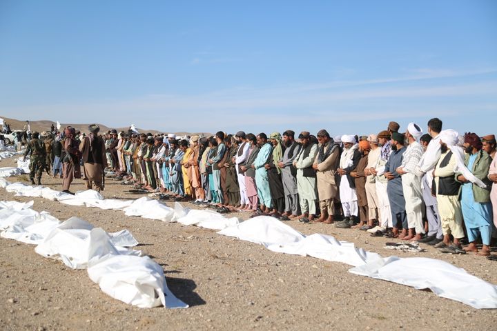 Άνθρωποι τελούν νεκρική προσευχή κοντά στα πτώματα των συγγενών τους, μετά τον φονικό σεισμό, στο Αφγανιστάν (9/10/2023)