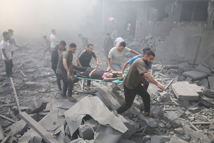 Palestinians evacuate wounded people after an Israeli airstrike in Rafah refugee camp, southern Gaza Strip, on Oct. 12, 2023. 