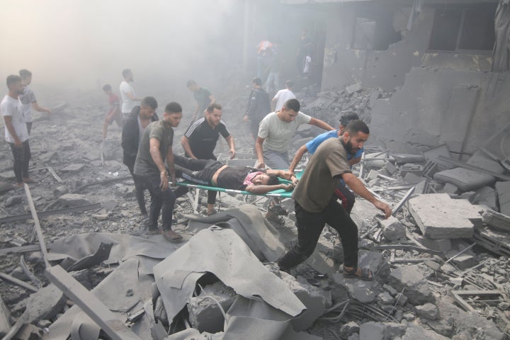 Palestinians evacuate wounded people after an Israeli airstrike in Rafah refugee camp, southern Gaza Strip, on Oct. 12, 2023.