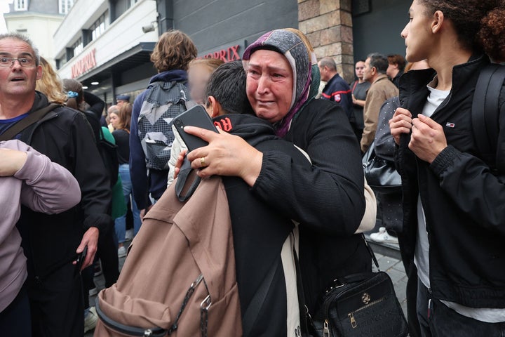 A student is comforted by a relative as he leaves Gambetta high school in Arras.