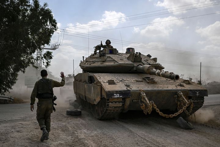 EDITORS NOTE: Graphic content / An Israeli soldier directs a Merkava battle tank as it deploys with other tanks along the border with the Gaza Strip in southern Israel on Oct. 13, as battles between Israel and the Palestinian Hamas movement continue for the seventh consecutive day. Thousands of people, both Israeli and Palestinians have died since Oct. 7, after Palestinian Hamas militants entered Israel in a surprise attack leading Israel to declare war on Hamas in the Gaza Strip enclave on Oct. 8.