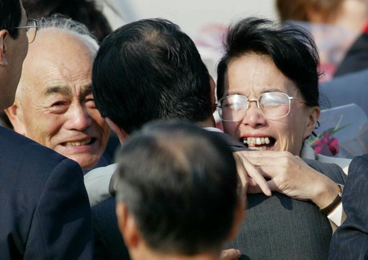 北朝鮮から24年ぶりに帰国し、家族らと再会を抱き合って喜ぶ拉致被害者の浜本富貴恵さん（右、47歳）。左は兄の雄幸さん＝2002年10月15日、東京・羽田空港