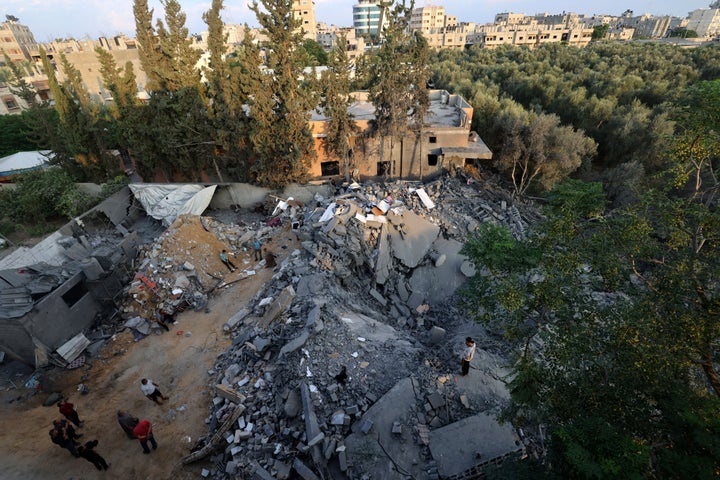 People inspect the damage to a building after Israeli strikes in the Rafah camp on the southern Gaza Strip on October 14, 2023. Thousands of Palestinians fled on October 14 to southern Gaza seeking refuge after Israel warned them to evacuate before an expected ground offensive against Hamas in retaliation for the deadliest attack in Israel's history. (Photo by MOHAMMED ABED / AFP) (Photo by MOHAMMED ABED/AFP via Getty Images)