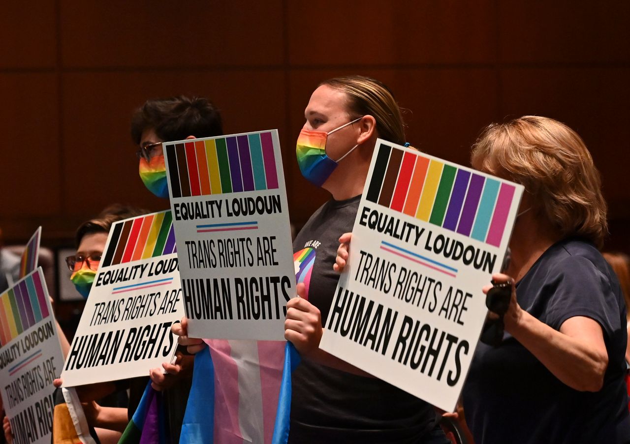 Supporters of Policy 8040 celebrate with signs as the transgender protection measures were voted into the school system's policies during a school board meeting at the Loudoun County Public Schools Administration Building on Aug. 11, 2021, in Ashburn, Virginia.